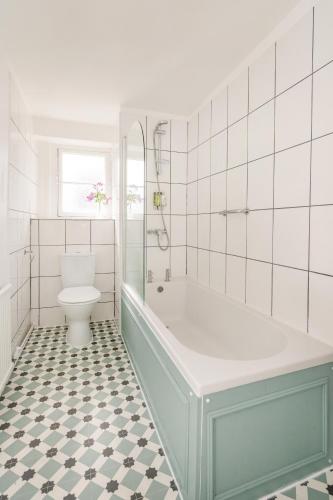 a white bathroom with a tub and a toilet at The Washington in Bristol