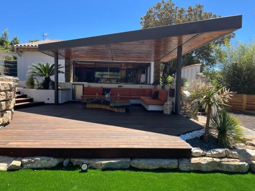 a pergola with a deck in a yard at La Pura Vida 34 in Pignan