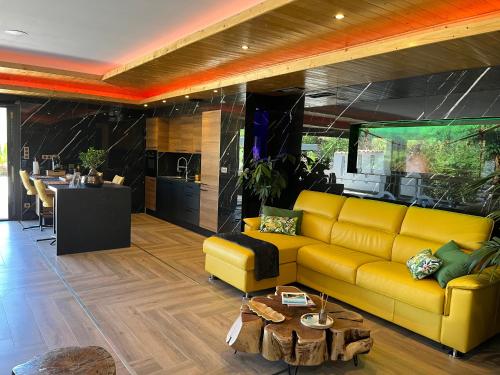 a living room with a yellow couch and a table at La Pura Vida 34 in Pignan