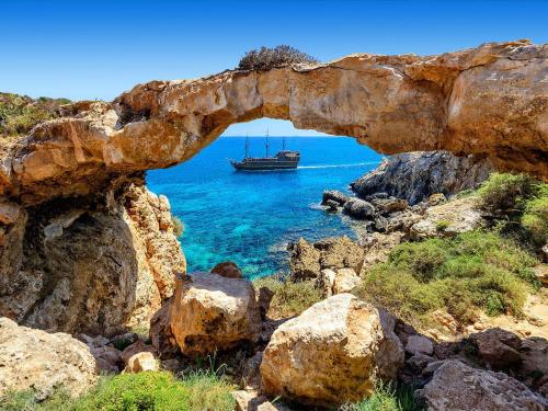 an archway with a boat in the water at Fig Tree Bay Residences 1 Lantiana Villa in Protaras