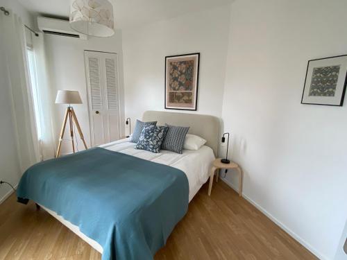 - une chambre blanche avec un lit et une couverture bleue dans l'établissement Le Guillaumont - Amazing 2-bedroom in the Old Town -StayInAntibes, à Antibes