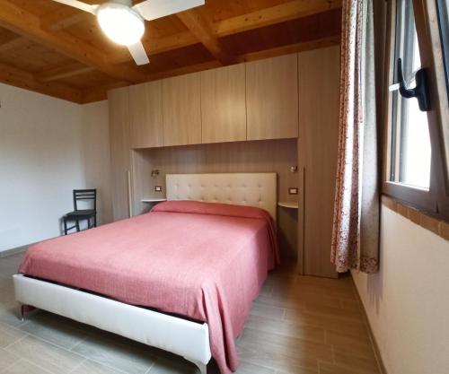 a bedroom with a bed with a red blanket at Agriturismo La tana della volpe in Alberese