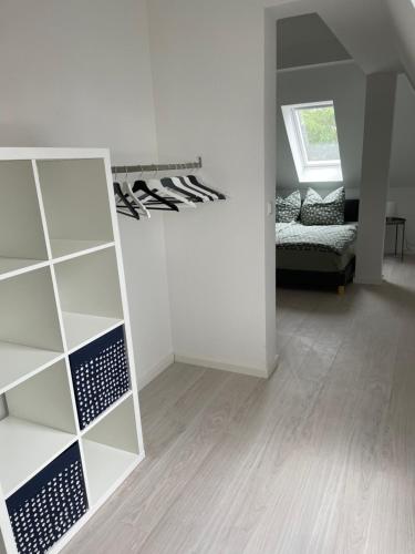a room with a white wall and a shelf with shoes at Moderne Ferienwohnung in Lutherstadt Wittenberg in Lutherstadt Wittenberg