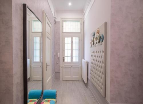 a hallway with a mirror and a blue chair at Boutique Apartment in Budapest