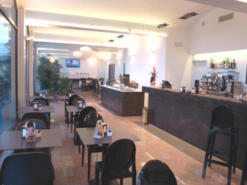 un ristorante con tavoli e sedie e un bar di Hotel Pico a Mirandola