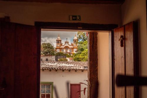 Una ventana abierta con vista a un edificio en Pousada Rústica, en Tiradentes