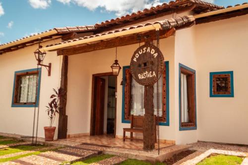 una casa con un cartel delante en Pousada Rústica, en Tiradentes