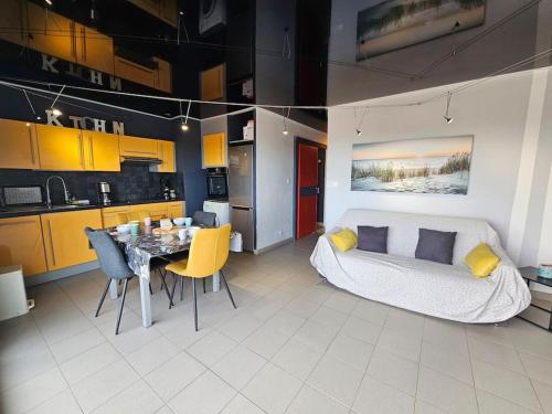 Il comprend un salon avec une table à manger et une cuisine. dans l'établissement Vue Panoramique front de Mer !, à Fleury