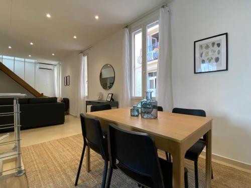 une salle à manger avec une table et des chaises en bois dans l'établissement Le Guillaumont - Amazing 2-bedroom in the Old Town -StayInAntibes, à Antibes