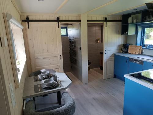 a small kitchen with a table in a tiny house at Tiny House & Alpaka-Erlebnis im Ruhner Land - Naturidylle pur in Ziegendorf