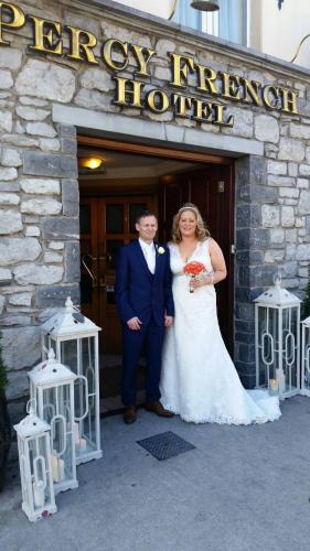 a bride and groom standing in front of a hotel at Percy French Hotel in Strokestown