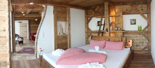 a bedroom with a bed with red and white pillows at Schönblick Hohenbogen in Neukirchen beim Heiligen Blut