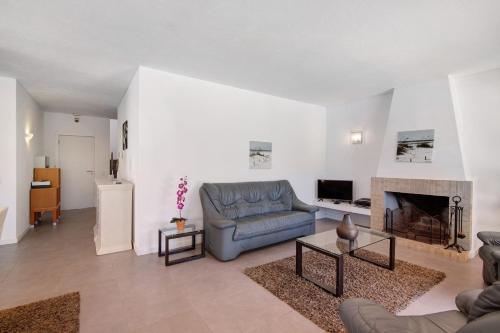 a living room with a couch and a fireplace at Villa Lynn - Quadradinhos in Almancil