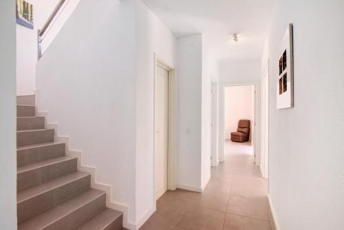 a hallway with white walls and stairs in a house at Villa Lynn - Quadradinhos in Almancil