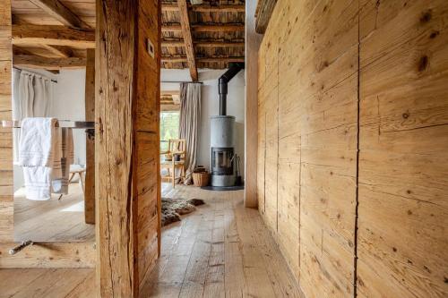 a room with a wooden wall and a fireplace at Chalet Dolomites Luxe con Spa, Piscine, Jacuzzi e Cinema Privato in Livinallongo del Col di Lana