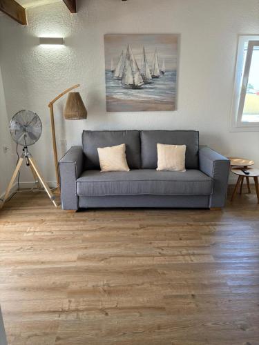 a living room with a couch and a fan at Apartamento Siete Pameras 1 in Cala en Blanes