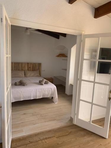 a bedroom with a bed and a door to a room at Apartamento Siete Pameras 1 in Cala en Blanes