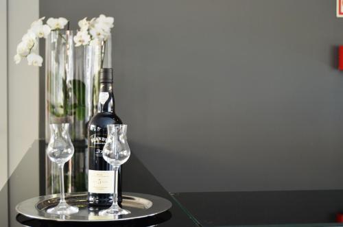 a bottle of wine and two wine glasses on a table at Madeira Bright Star by Petit Hotels in Funchal