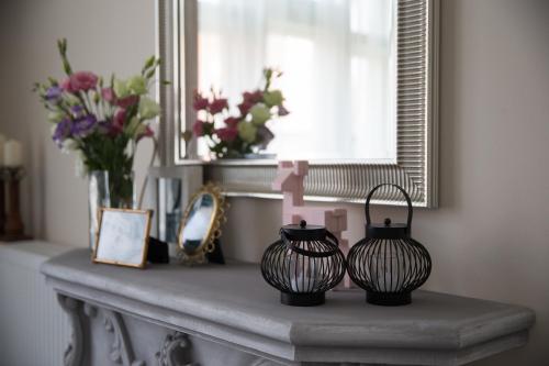 two black vases sitting on a mantle with flowers at Boutique Apartment in Budapest