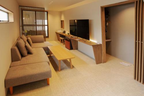 a living room with a couch and a table at Kusatsu Onsen Eidaya in Kusatsu