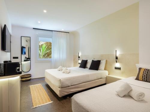 a hotel room with two beds and a flat screen tv at Yalos Hotel Sunset view Mykonos town private rooms in Mýkonos City