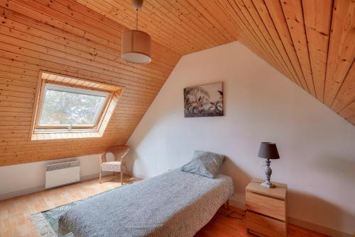 une chambre avec un lit et un plafond en bois dans l'établissement Maison pour 4 adultes, 1 enfant à 200m de la plage, au Guilvinec