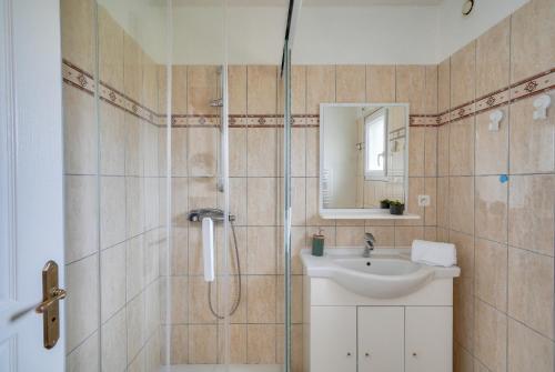 une salle de bain avec un lavabo et une douche dans l'établissement Maison pour 4 adultes, 1 enfant à 200m de la plage, au Guilvinec