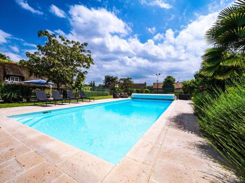une grande piscine avec de l'eau bleue dans une cour dans l'établissement Maison Piscine & Tennis - Collection Idylliq, à Muids