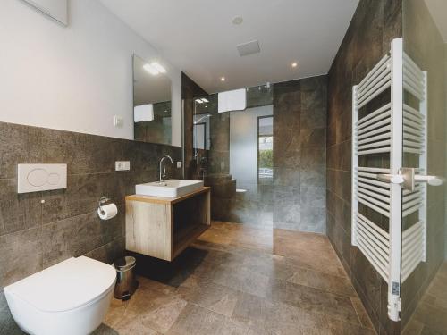 a bathroom with a toilet and a sink at First IN Mountain Chalets by we rent in Kaprun