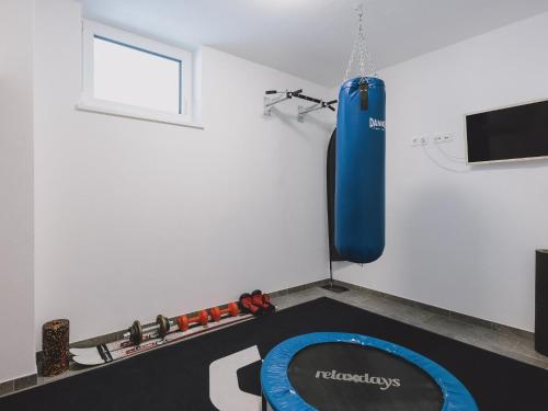 a gym with a blue punching bag hanging from a wall at First IN Mountain Chalets by we rent in Kaprun
