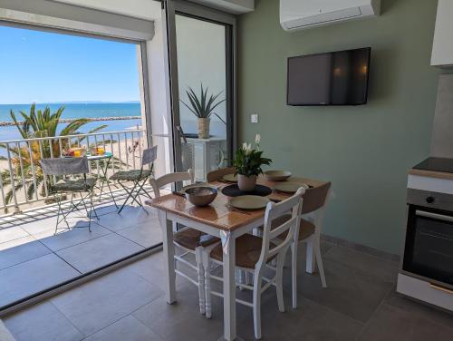 une salle à manger avec une table et une vue sur l'océan dans l'établissement Sol-y-Days le Royal Grand studio centre ville vue mer avec parking, au Grau-du-Roi