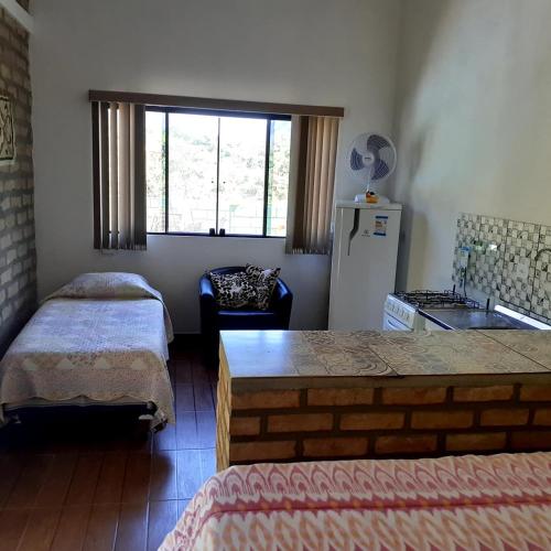a room with two beds and a kitchen with a refrigerator at Vyzuh in Vale do Capao