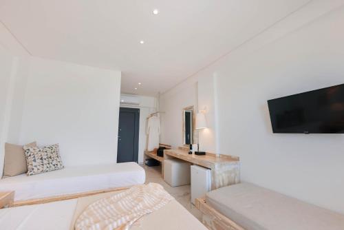 a living room with a couch and a tv on a wall at Acron Suites in Limenaria