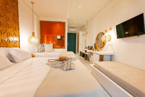 a living room with two beds and a television at Acron Suites in Limenaria