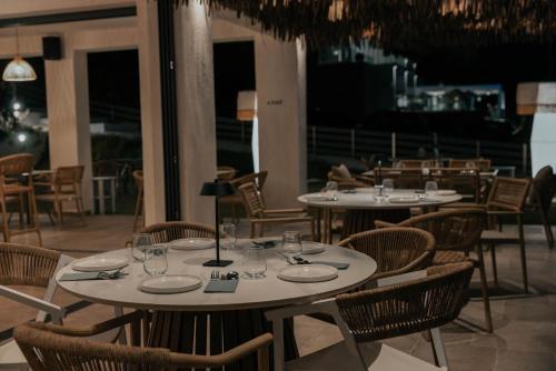 a restaurant with tables and chairs with glasses on them at Acron Suites in Limenaria