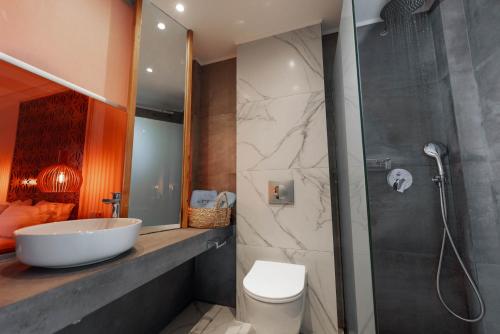a bathroom with a shower and a sink and a toilet at Acron Suites in Limenaria