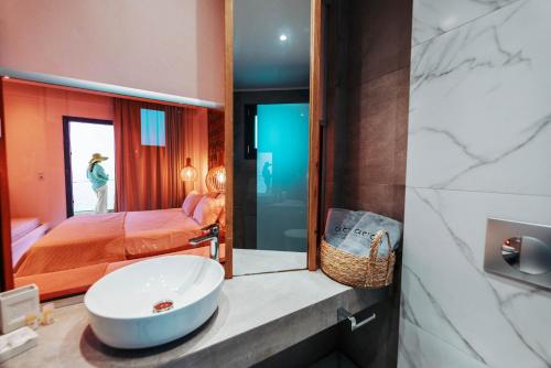 a bathroom with a sink and a bed and a mirror at Acron Suites in Limenaria