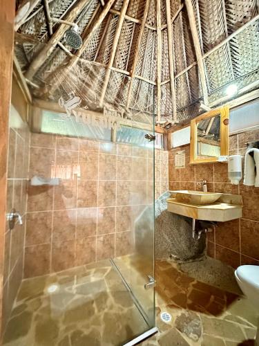 a bathroom with a shower and a sink at Eco Hostal Yuluka in El Zaino