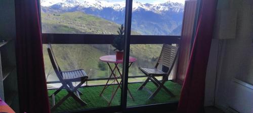 d'un balcon avec deux chaises et une table devant une fenêtre. dans l'établissement Studio montagne 4 personnes, au Corbier