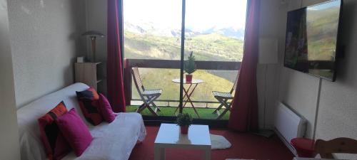 un salon avec un canapé et une grande fenêtre dans l'établissement Studio montagne 4 personnes, au Corbier