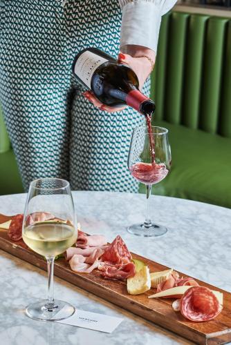 a person pouring wine into two wine glasses at Mercure Paris Nanterre in Nanterre