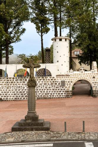 a statue in front of a brick wall with a bridge at Parador de Cruz de Tejeda in Tejeda