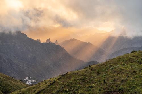 a view of a mountain range with the sun shining at Parador de Cruz de Tejeda in Tejeda