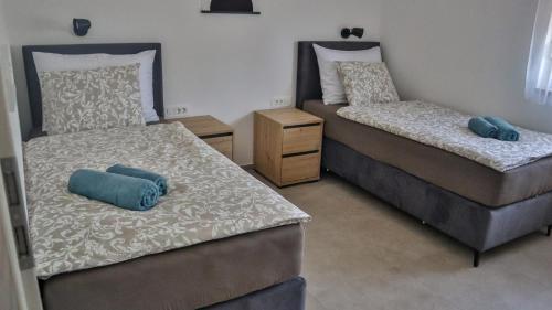 a bedroom with two beds with blue pillows on them at Zelena oaza in Krk