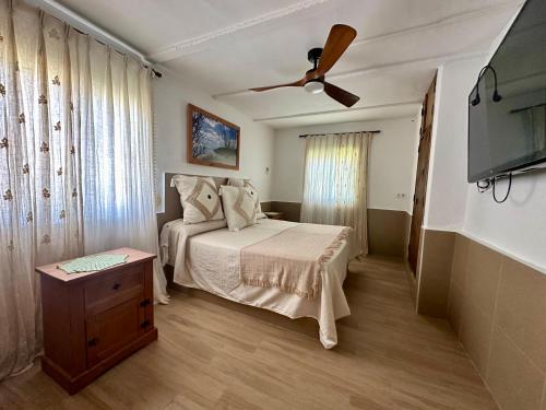 a bedroom with a bed and a ceiling fan at House Beach in Bolonia