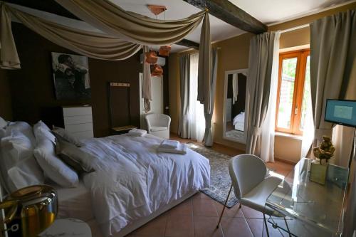 ein Schlafzimmer mit einem Bett, einem Schreibtisch und einem Fernseher in der Unterkunft La perla di Asti con Jacuzzi e Sauna in Asti