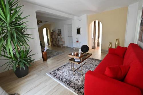 ein Wohnzimmer mit einem roten Sofa und einem Tisch in der Unterkunft La perla di Asti con Jacuzzi e Sauna in Asti