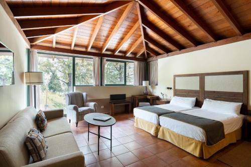 a bedroom with a bed and a couch at Parador de Cruz de Tejeda in Tejeda