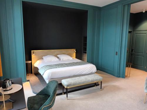 a bedroom with a large bed with blue walls at DOMITYS - Le château de la Pilule in Saint-Quentin