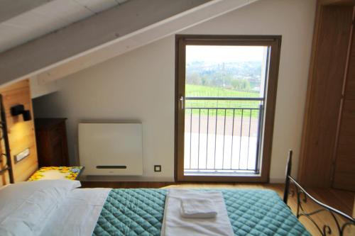 a bedroom with a bed and a large window at Le Vignole in Vezzano